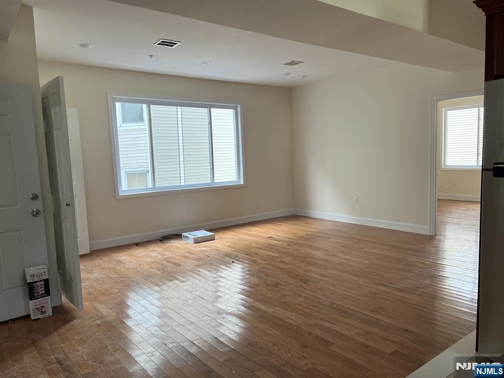 80-82 Madison Street Paterson, NJ 07501 - Photo 4 of 7 an empty room with wooden floor and windows