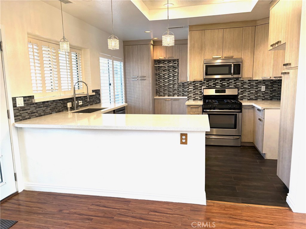 7280 Comiso Way Rancho Cucamonga, CA 91701 - Photo 19 of 66 a kitchen with stainless steel appliances granite countertop a stove a sink and a microwave