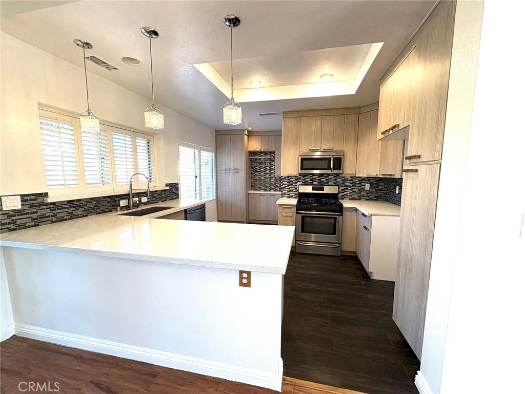 7280 Comiso Way Rancho Cucamonga, CA 91701 - Photo 20 of 66 a kitchen with stainless steel appliances kitchen island granite countertop a sink a stove and a refrigerator