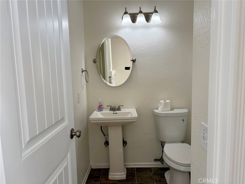 7280 Comiso Way Rancho Cucamonga, CA 91701 - Photo 29 of 66 a bathroom with a toilet a sink and mirror