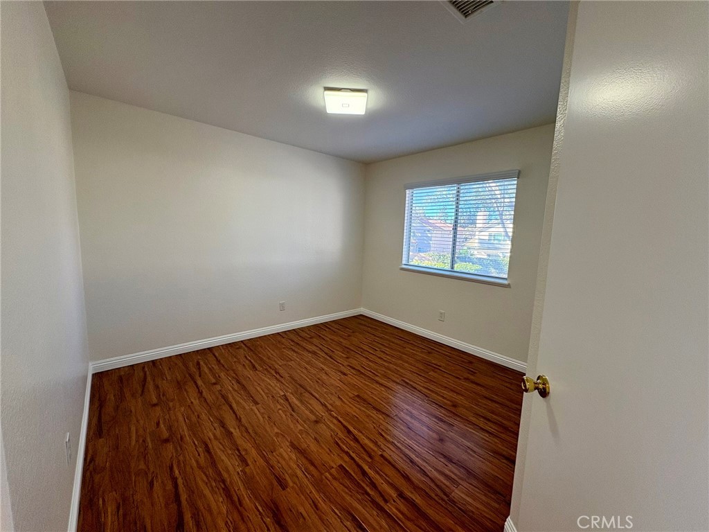 7280 Comiso Way Rancho Cucamonga, CA 91701 - Photo 55 of 66 an empty room with wooden floor and windows
