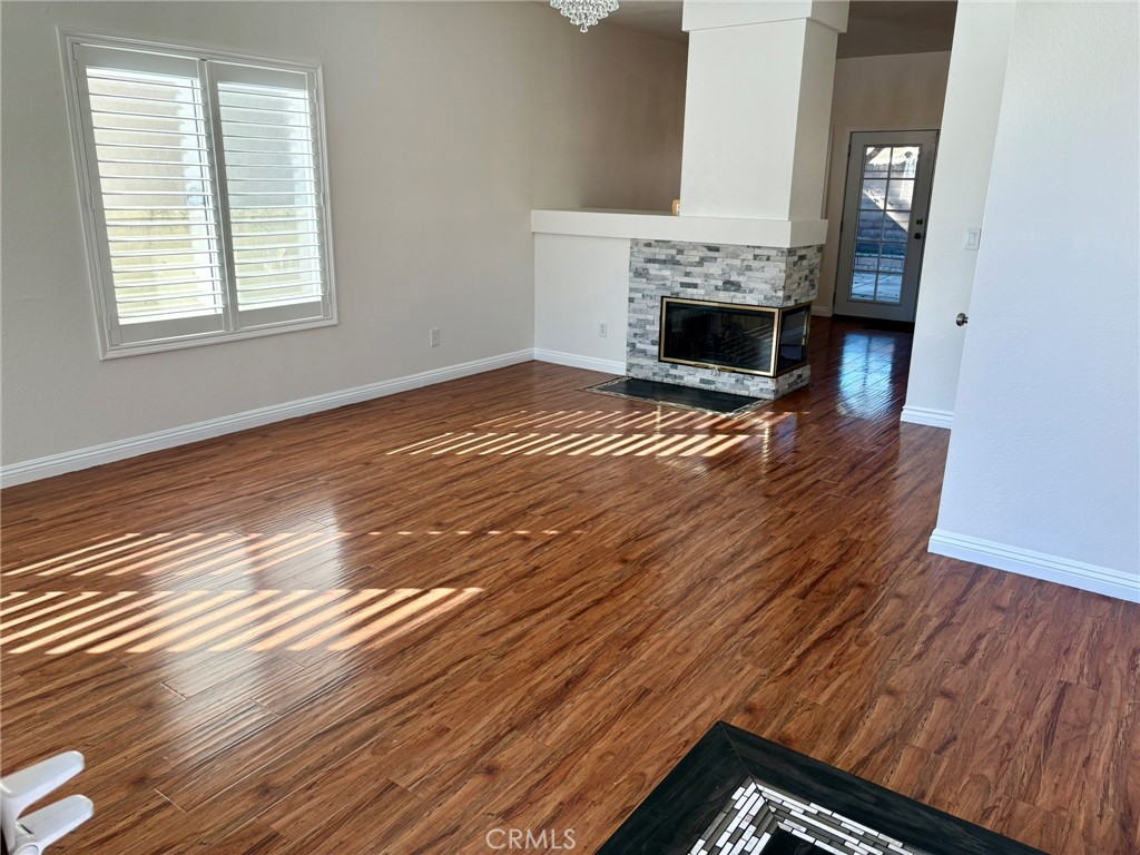 7280 Comiso Way Rancho Cucamonga, CA 91701 - Photo 6 of 66 an empty room with wooden floor fireplace and windows