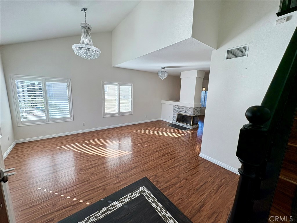 7280 Comiso Way Rancho Cucamonga, CA 91701 - Photo 8 of 66 a view of an empty room with wooden floor and a window