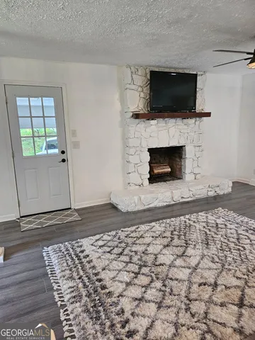 a living room with a fireplace a flat screen tv and a window