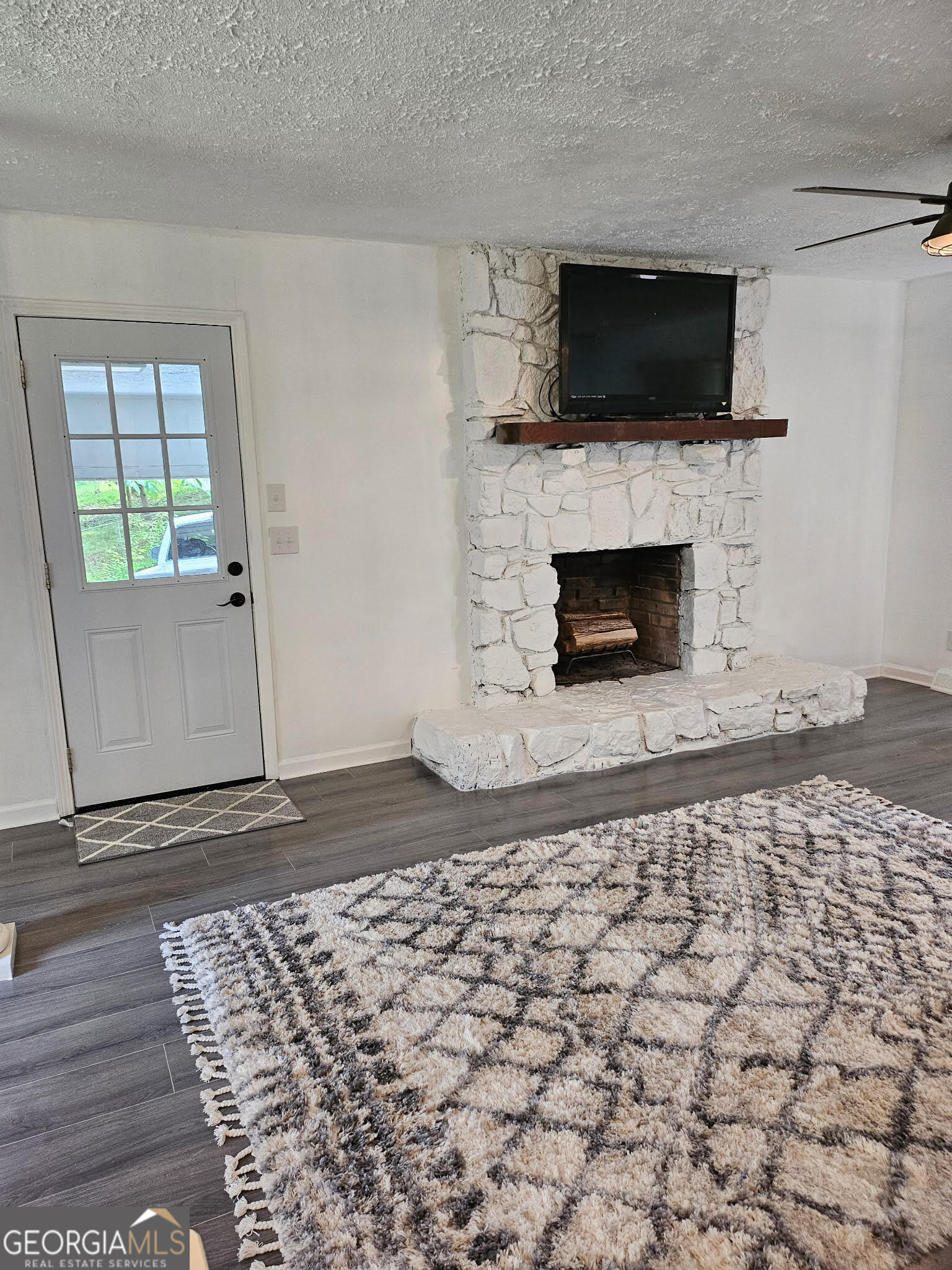 5 Red Fox Drive Southwest Rome, GA 30165 - Photo 5 of 22 a living room with a fireplace a flat screen tv and a window