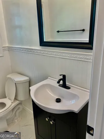 a bathroom with a sink a toilet and mirror