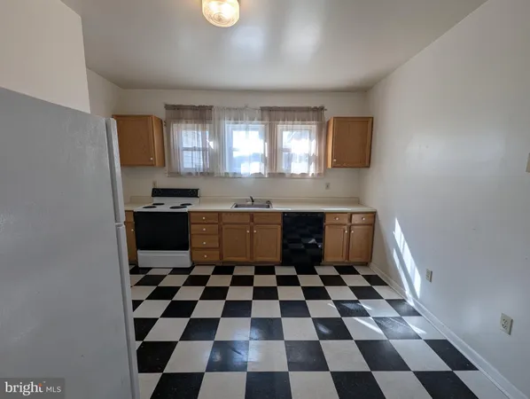 a kitchen with a checkered floor and white cabinets