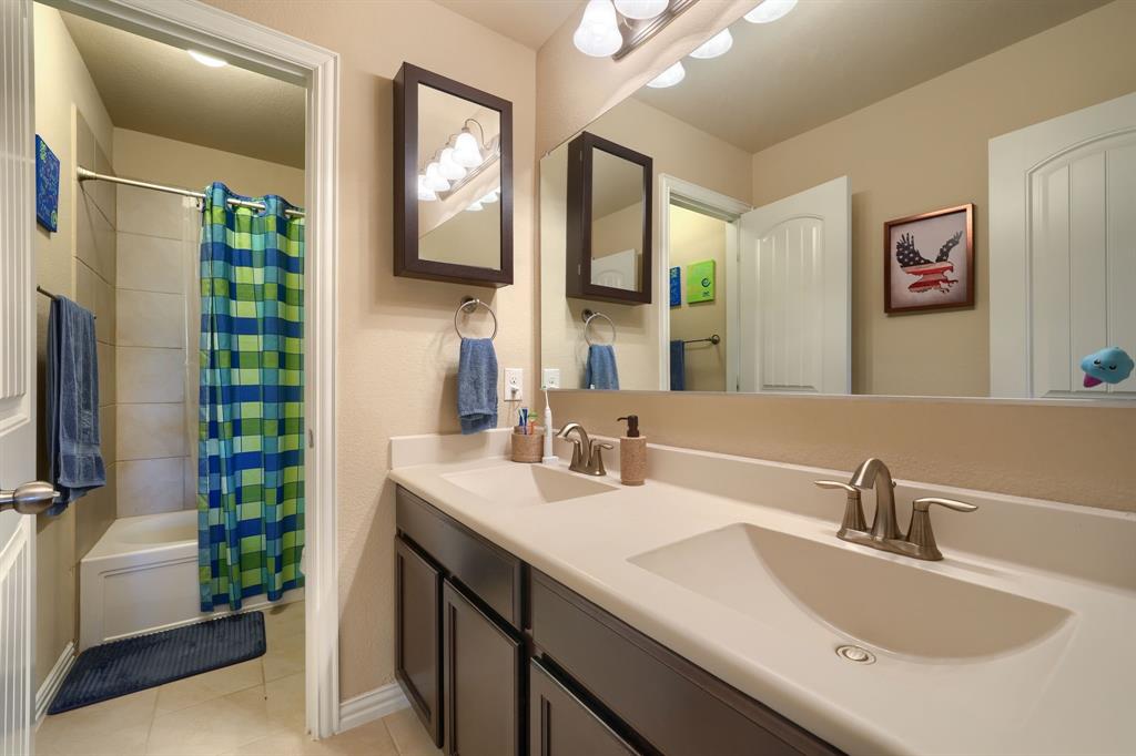 12417 Hitch Rack Way McKinney, TX 75071 - Photo 15 of 17 Bathroom with shower / bath combo with shower curtain, dual sinks, tile floors, and large vanity