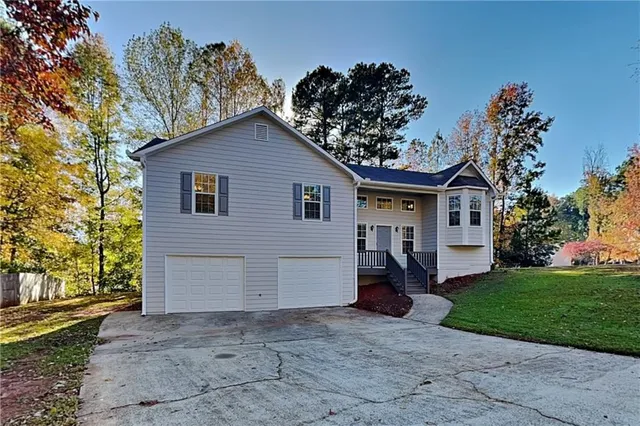 a view of a house with a yard and garage