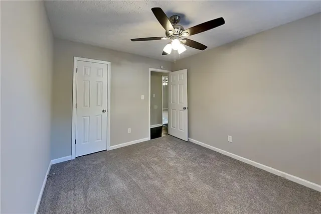 an empty room with chandelier fan