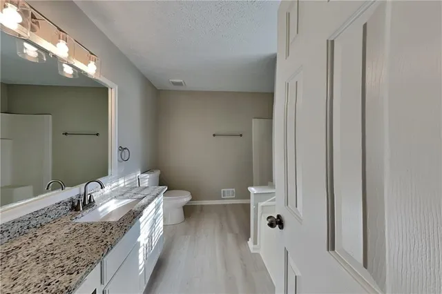 a bathroom with a granite countertop sink and a mirror
