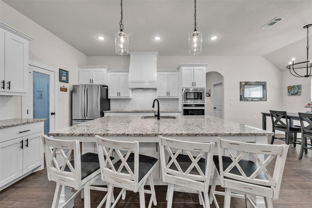 3000 Westfork Way Springtown, TX 76082 - Photo 16 of 35 a kitchen with stainless steel appliances granite countertop a kitchen island and chairs in it