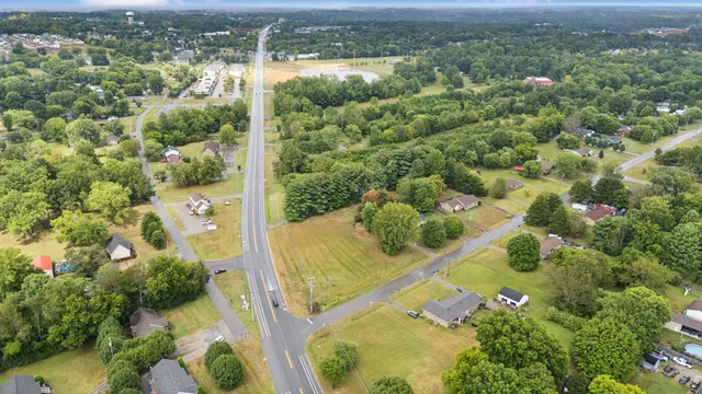 an aerial view of residential houses with outdoor space and trees