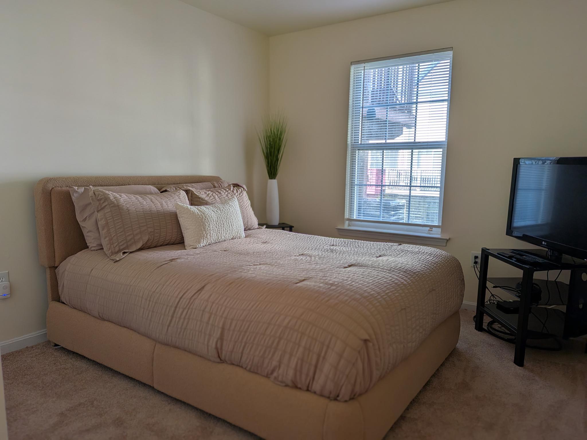 4240 Applegate Lane, Unit 5 Suitland, MD 20746 - Photo 16 of 27 a large bed sitting in a bedroom next to a window