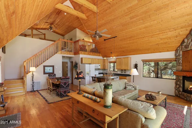 a living room with furniture and a dining table with wooden floor