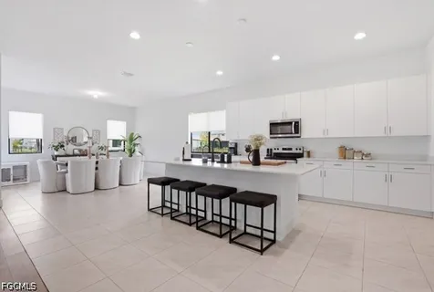 a kitchen with white cabinets and sink