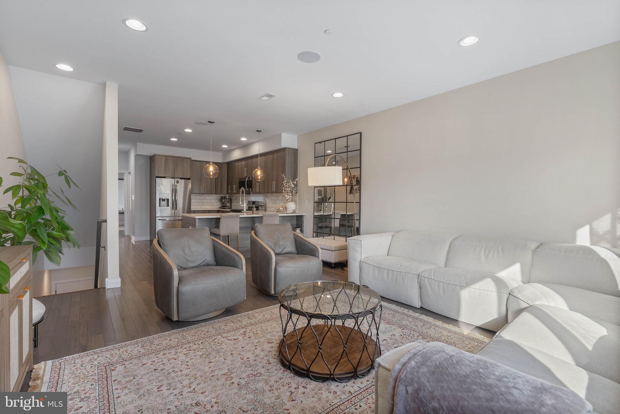 a living room with furniture and a view of kitchen