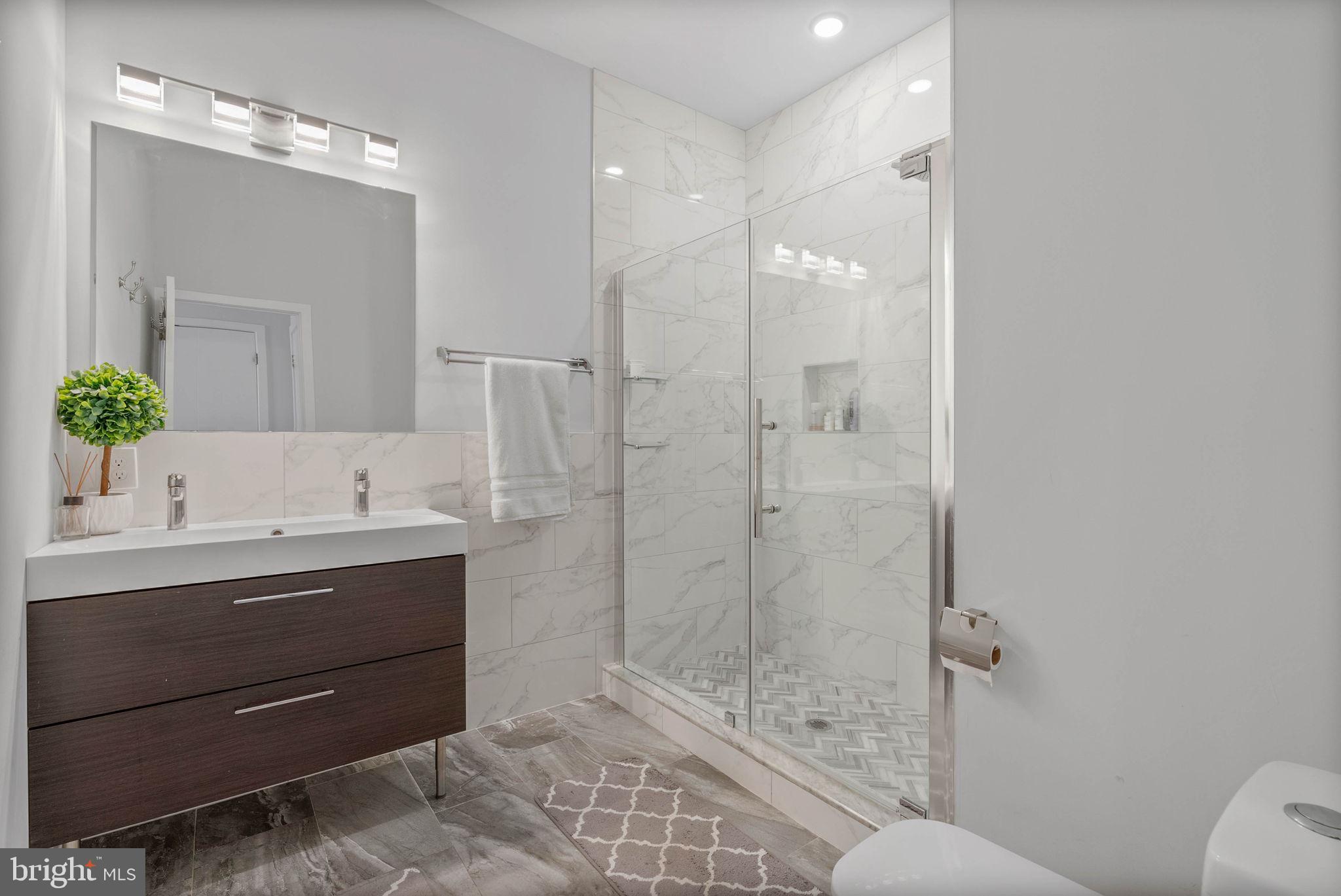 1753 North Marshall Street, Unit B Philadelphia, PA 19122 - Photo 11 of 34 a bathroom with a double vanity sink mirror and shower