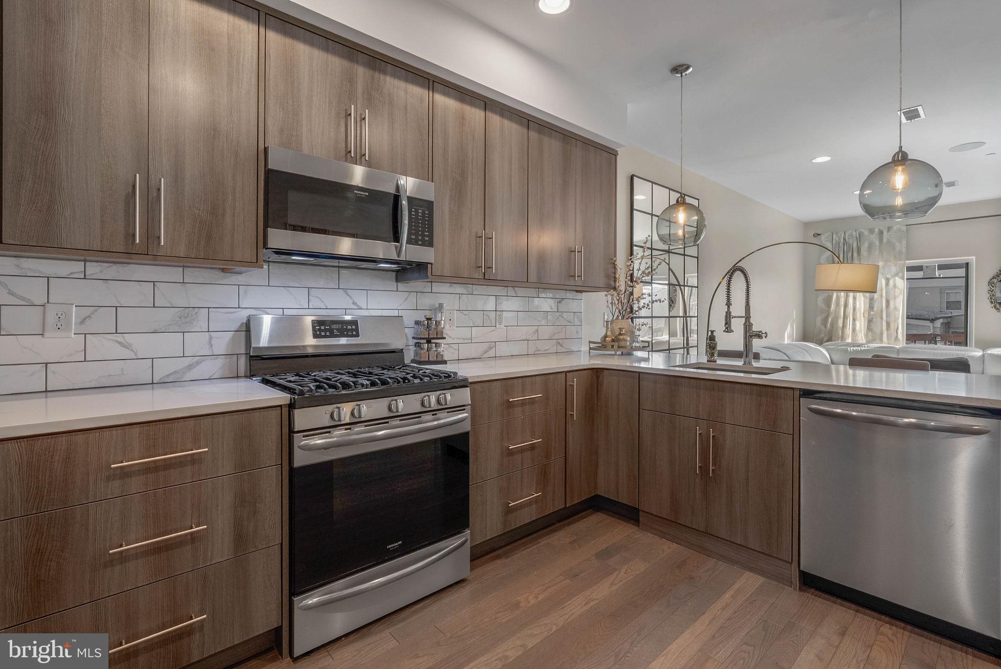 1753 North Marshall Street, Unit B Philadelphia, PA 19122 - Photo 8 of 34 a kitchen with stainless steel appliances wooden cabinets and a stove top oven