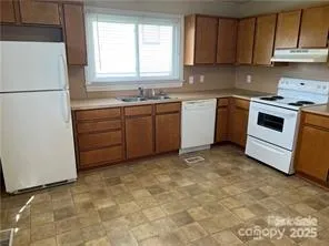 a kitchen with a stove sink and cabinets