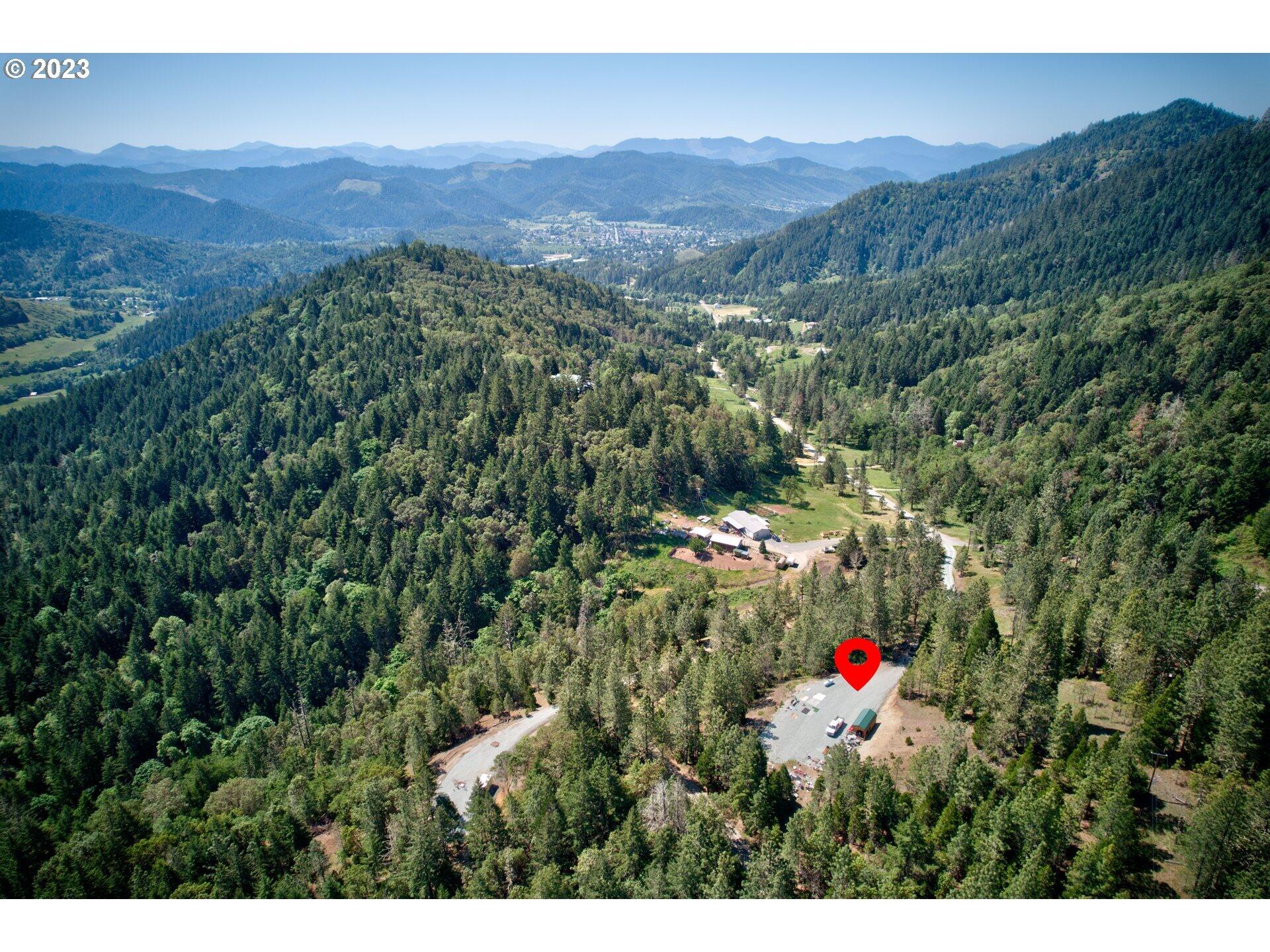 2133 Spring Brook Road Myrtle Creek, OR 97457 - Photo 17 of 33 a view of a lush green hillside and a building