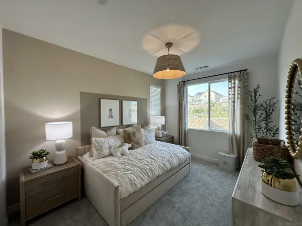 a spacious bedroom with a bed and a chandelier
