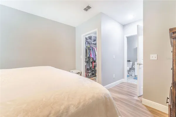 a bedroom with a large bed and a chandelier