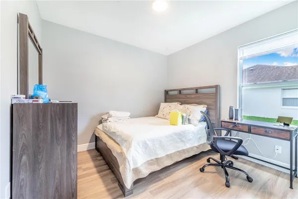 a bedroom with a bed a table and chair