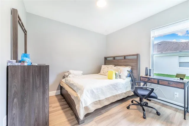 a bedroom with a bed a table and chair