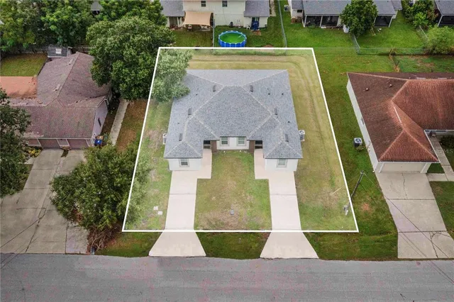 an aerial view of a house with a yard