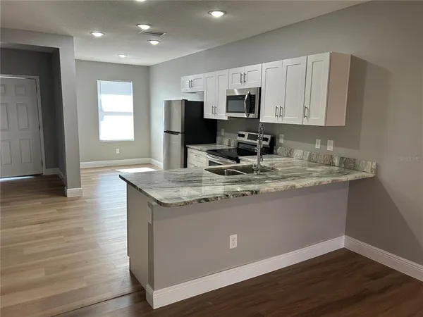 a kitchen with stainless steel appliances granite countertop a sink stove and microwave