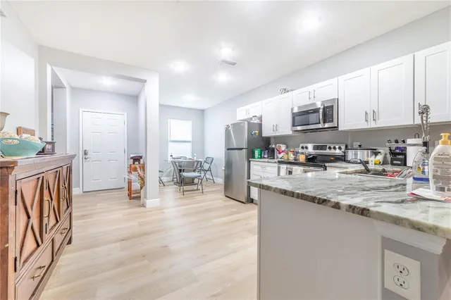 a kitchen with stainless steel appliances granite countertop a sink a stove top oven a counter space and cabinets