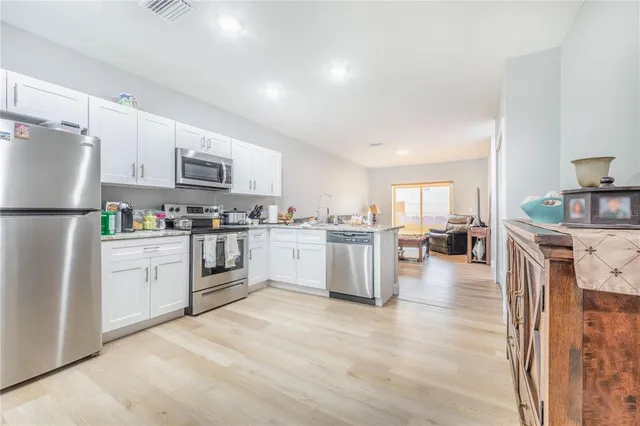 a kitchen with white cabinets and stainless steel appliances