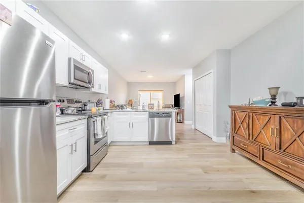 a kitchen with white cabinets sink and stainless steel appliances