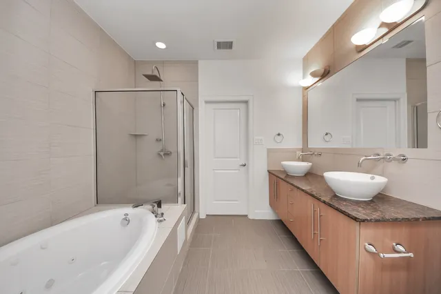 a spacious bathroom with a tub sink and mirror