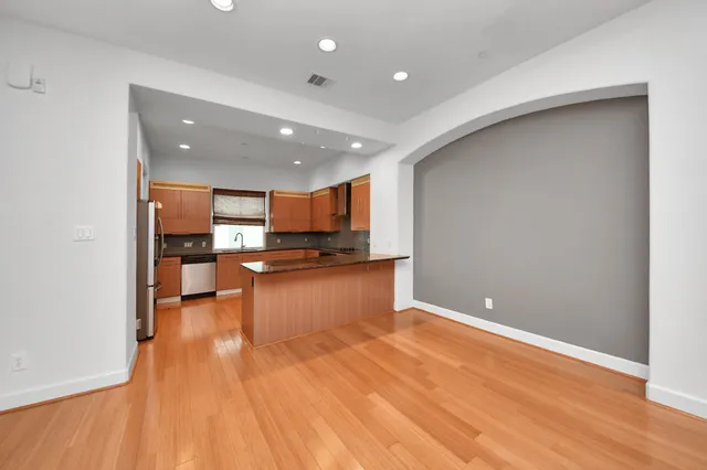 a view of kitchen with kitchen island wooden floor and center island