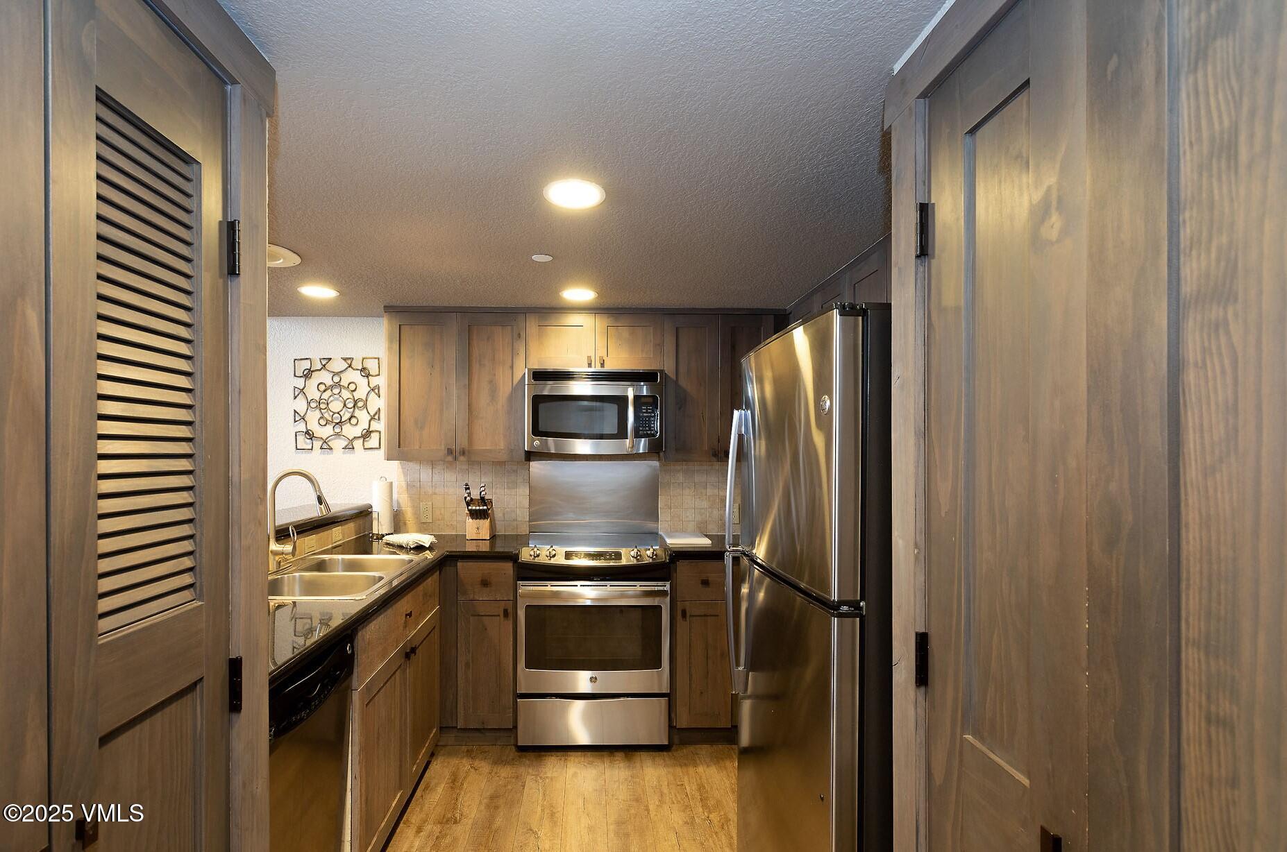 210 Offerson Road, Unit R317 WEEK 4 Beaver Creek, CO 81620 - Photo 7 of 29 a kitchen with a refrigerator and a sink