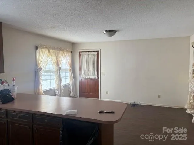 a view of kitchen with granite countertop cabinets and window