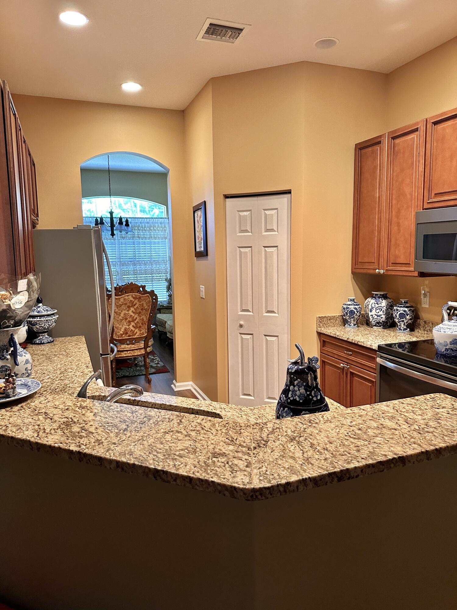 14085 86th Road North Loxahatchee, FL 33470 - Photo 16 of 28 a kitchen with granite countertop a sink a stove and cabinets