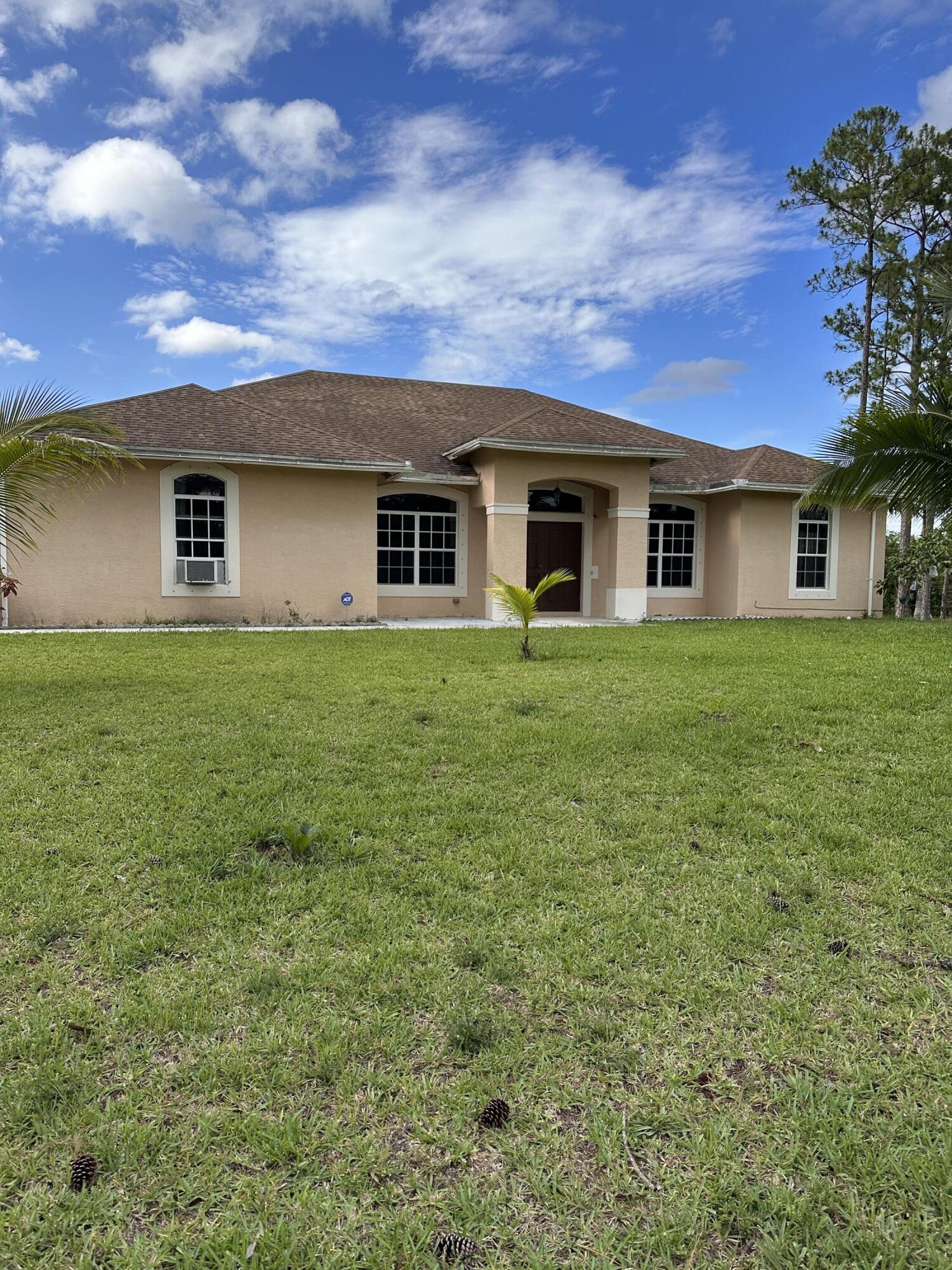 14085 86th Road North Loxahatchee, FL 33470 - Photo 2 of 28 a front view of a house with a garden