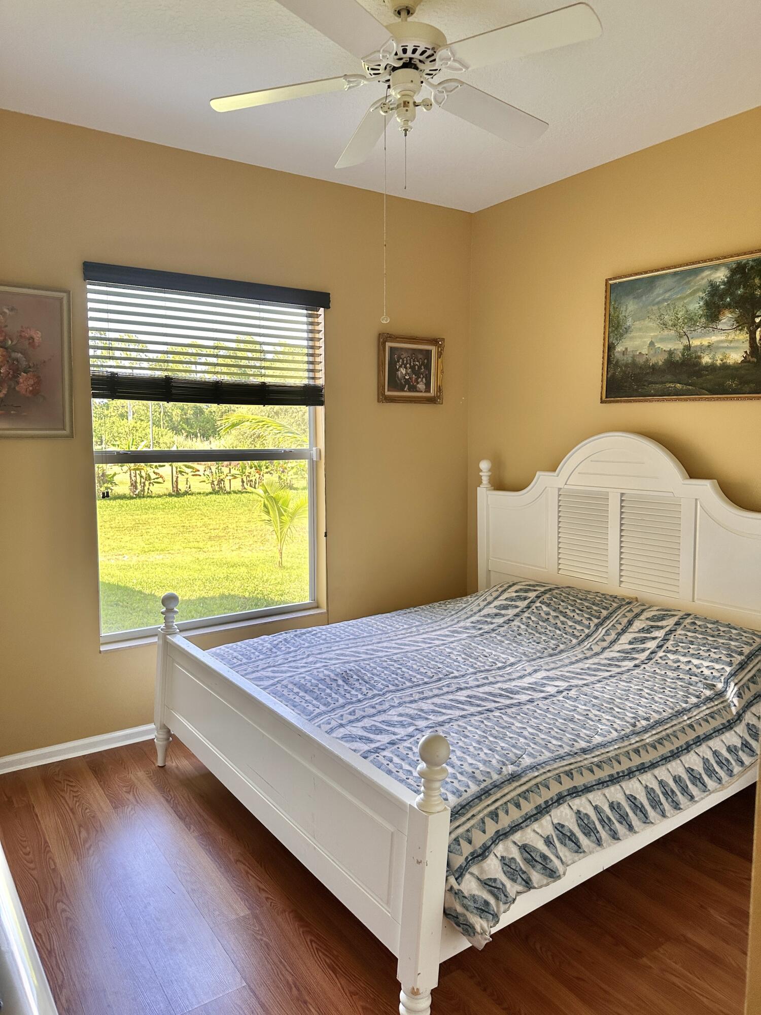 14085 86th Road North Loxahatchee, FL 33470 - Photo 25 of 28 a bedroom with a bed and wooden floor