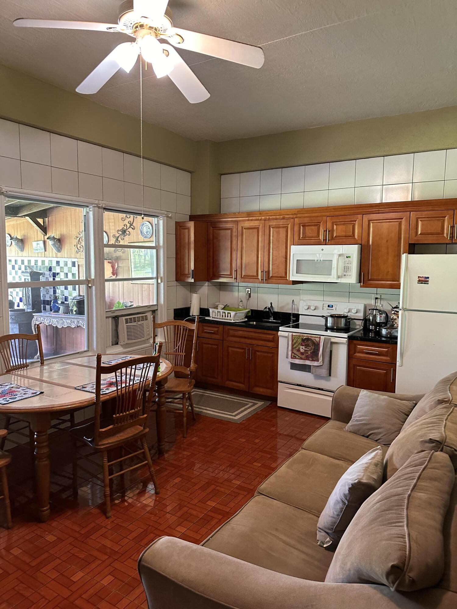 14085 86th Road North Loxahatchee, FL 33470 - Photo 27 of 28 a living room with stainless steel appliances furniture and a kitchen view