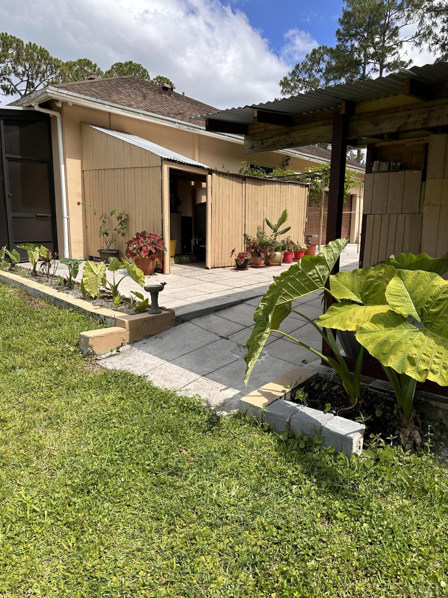 14085 86th Road North Loxahatchee, FL 33470 - Photo 9 of 28 a view of a house with backyard outdoor seating area and furniture