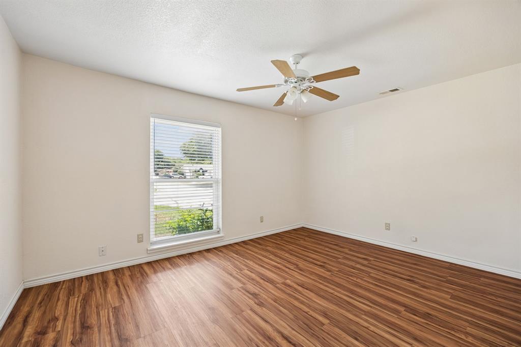 6221 Pine Street Rowlett, TX 75089 - Photo 6 of 12 Spacious room featuring wood-finish flooring, a ceiling fan with light fixture, and a window with horizontal blinds