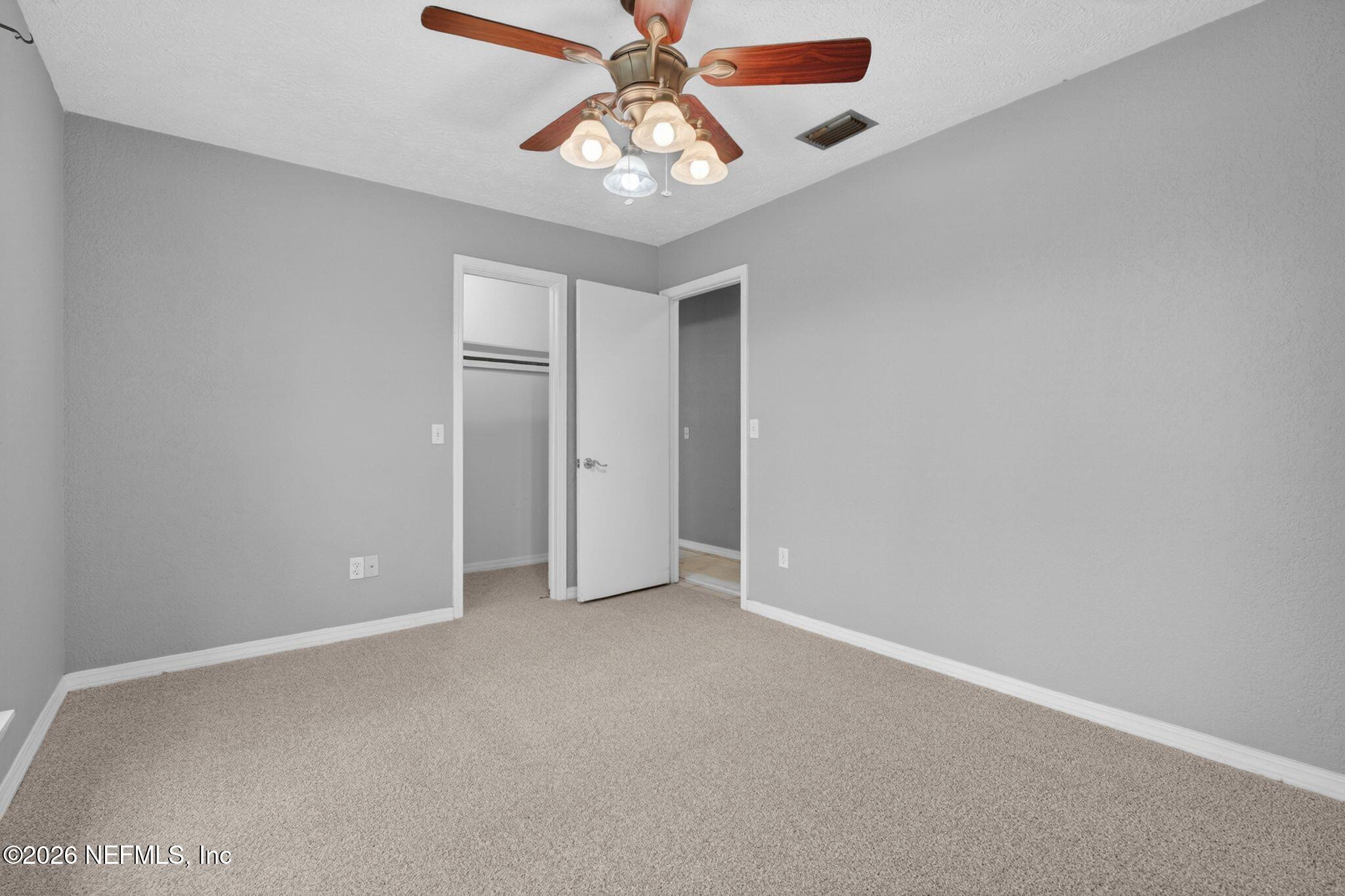 138 Ridgefield Court Orange Park, FL 32065 - Photo 36 of 64 an empty room with chandelier fan and windows