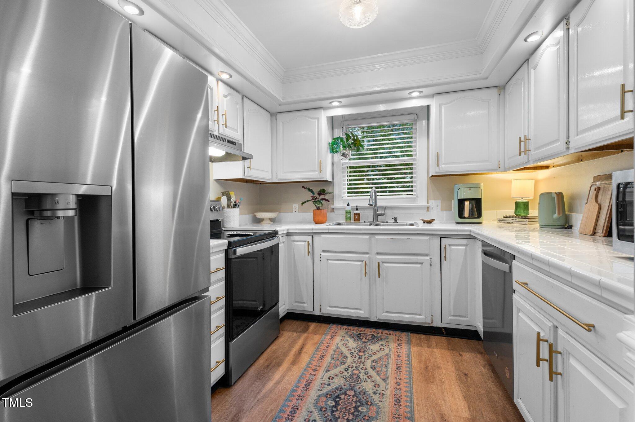 3541 East Jameson Road Raleigh, NC 27604 - Photo 12 of 38 a kitchen with cabinets stainless steel appliances a sink and a window
