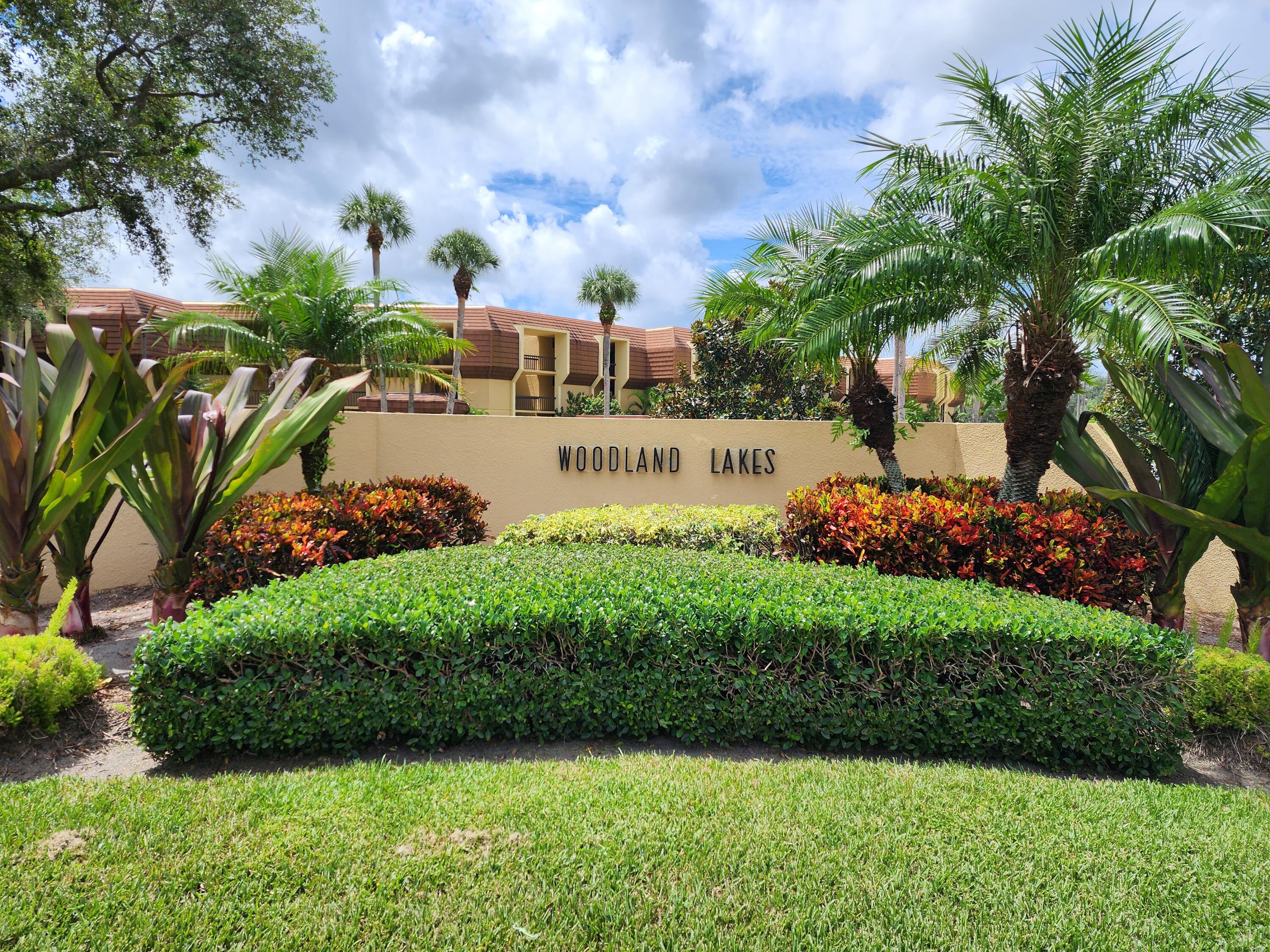 5344 Woodland Lakes Drive, Unit 223 Palm Beach Gardens, FL 33418 - Photo 2 of 46 a view of a park that has large trees