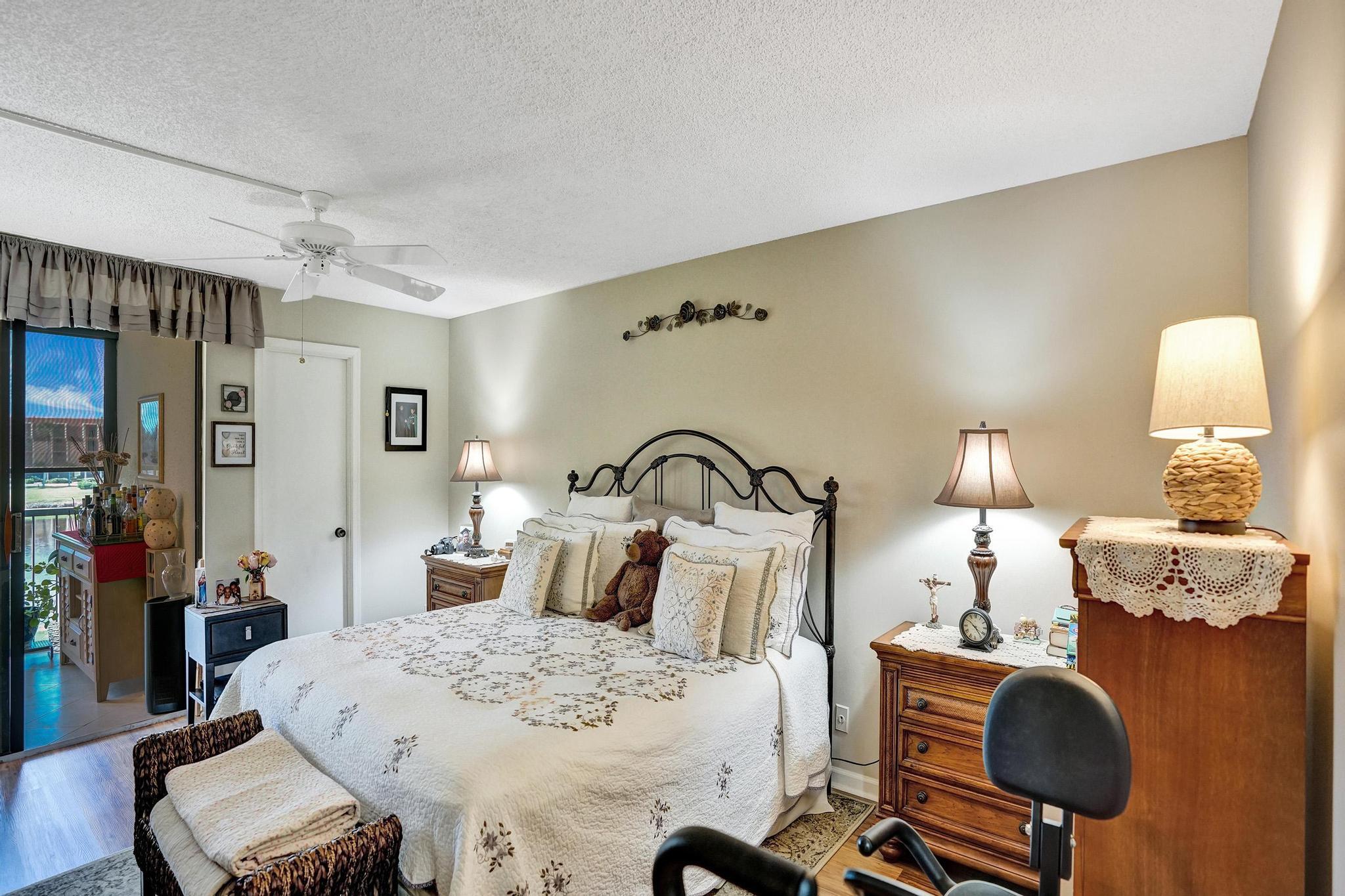 5344 Woodland Lakes Drive, Unit 223 Palm Beach Gardens, FL 33418 - Photo 25 of 46 a bedroom with a bed and dresser