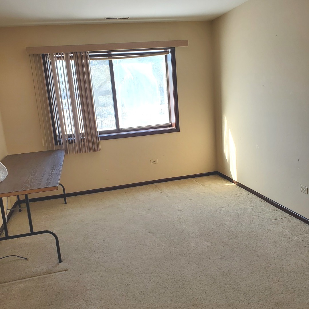9242 Gross Point Road, Unit 107 Skokie, IL 60077 - Photo 10 of 13 an empty room with windows