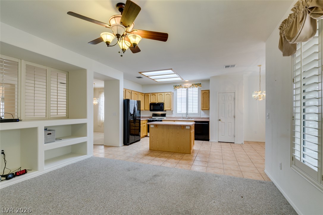 2189 Chapman Ranch Drive Henderson, NV 89012 - Photo 20 of 60 Tile flooring and built-in shelving connect the carpeted living space to the adjacent kitchen.